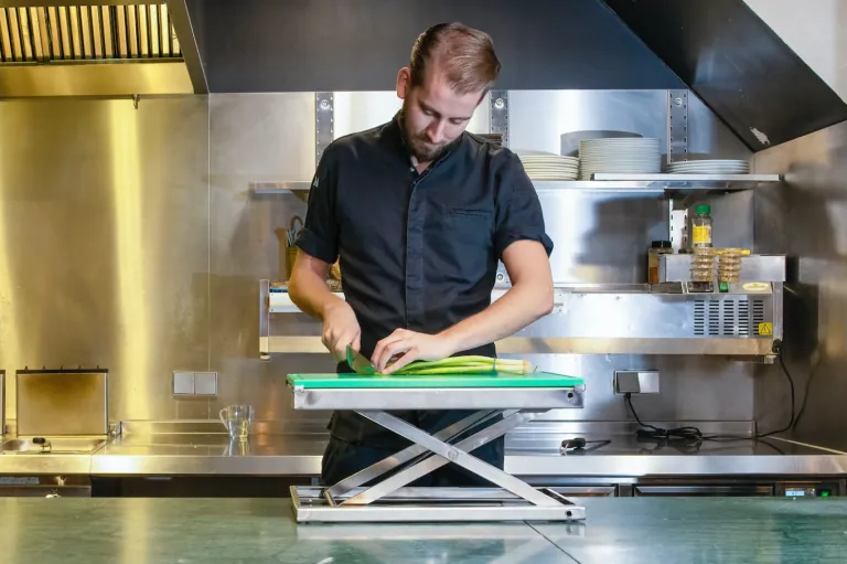 Chef cutting upright with the ErgoCutter on a stainless steel worktop